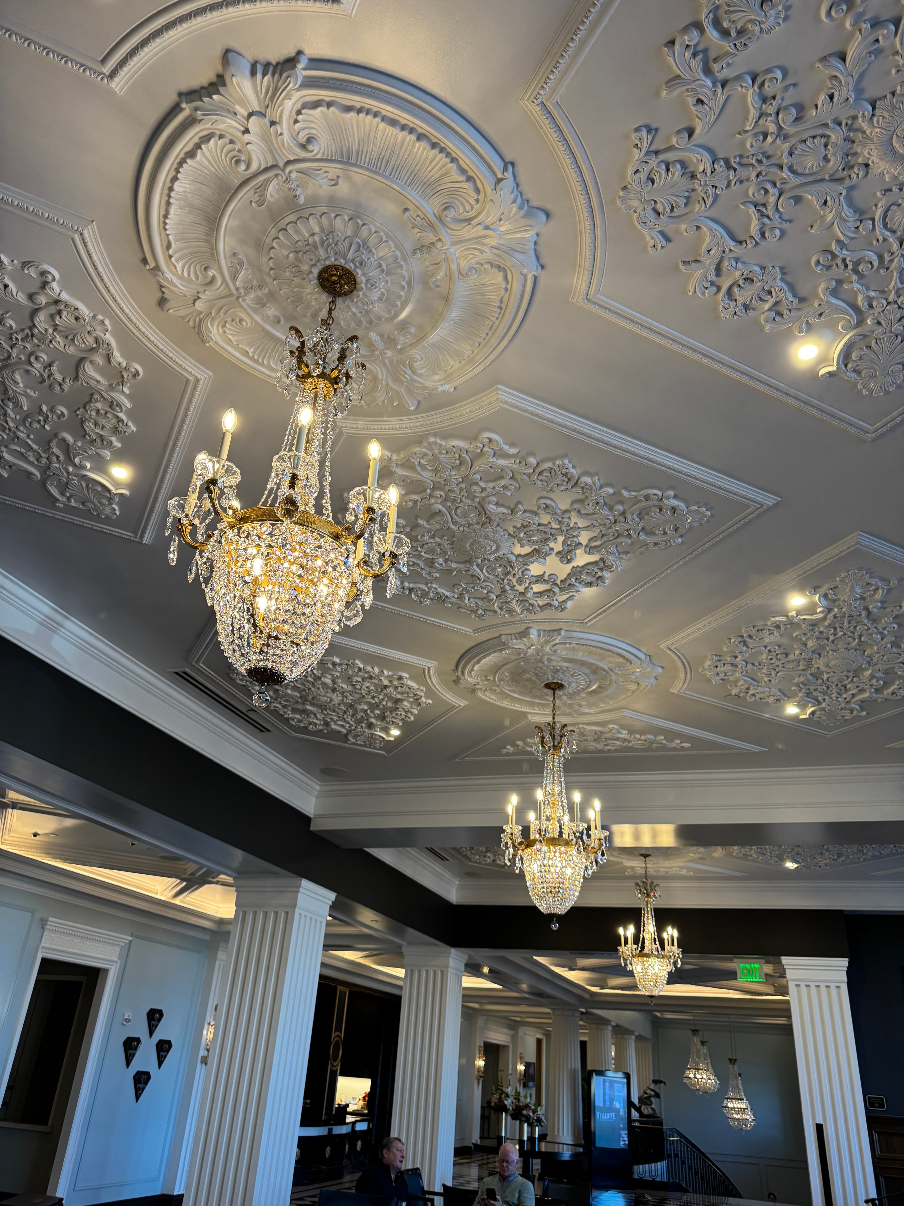 Ornate crystal chandeliers with gold fittings in an elegant ballroom