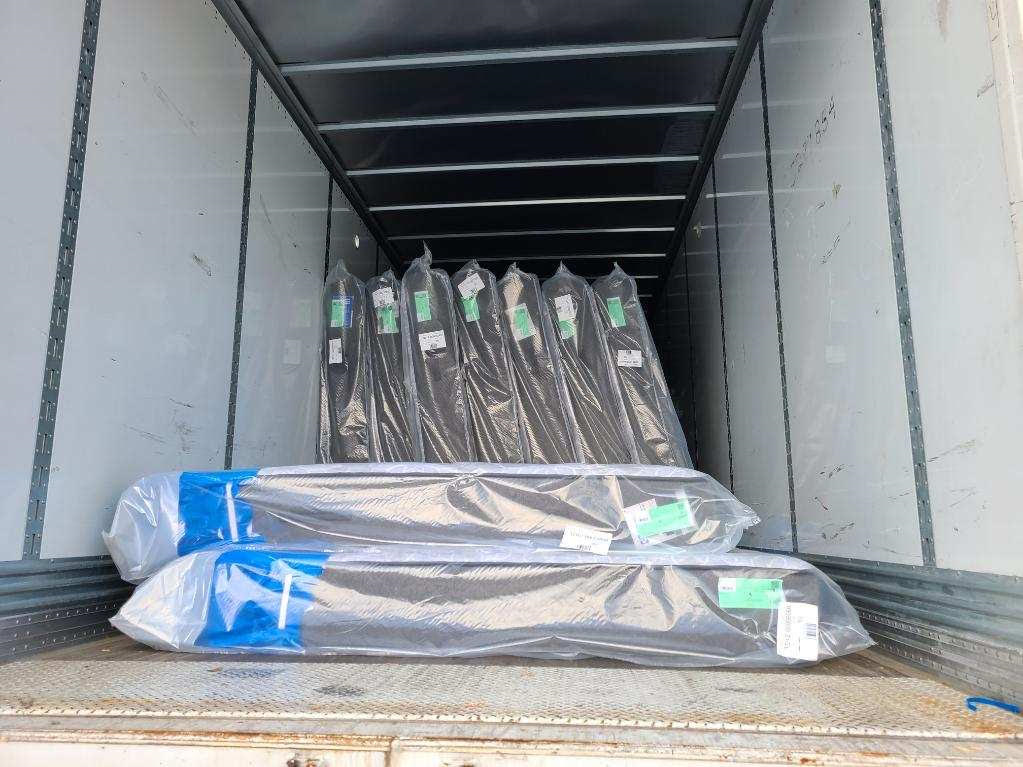 New mattresses wrapped in plastic inside a delivery truck